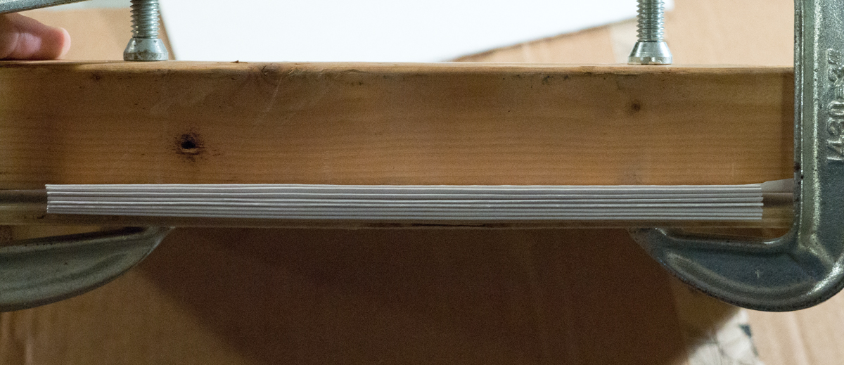 The clamped down pages of my book, ready for an application of PVA glue to the spine
